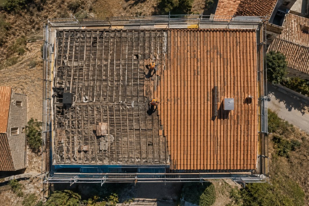 Vista cenital de un cambio de tejado con media cubierta desmontada y media ya cubierta